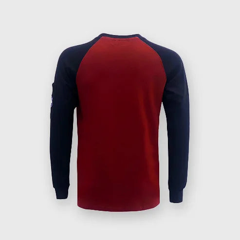 A worker wearing a Bocomal FR buttonless two-tone t-shirt in an industrial setting.