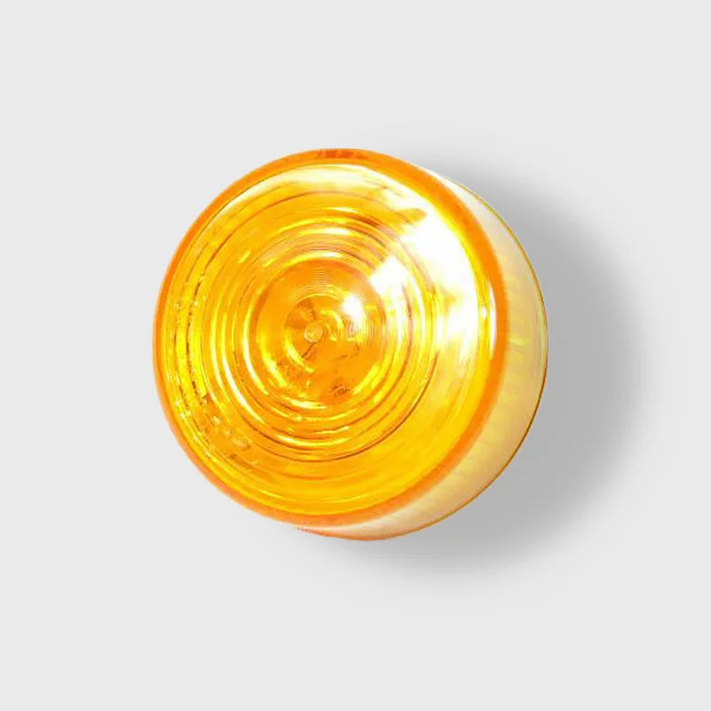 A bright amber 2-inch round sealed light illuminating a dark road.